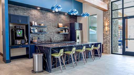 A modern kitchen with a bar area and a trash bin.